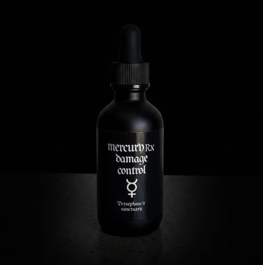 A black dropper bottle labeled 'mercuryRx damage control' with a mercury symbol, photographed against a solid black background.